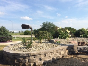 Picture of  the Friends of the Stone Arch Trail's flower mound renovation project under the Agricultural Symbol Sculpture.